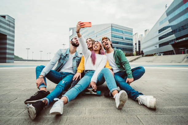 wielorasowi przyjaciele robiący selfie w skate parku - koncepcja szczęśliwej młodzieży i przyjaźni z młodymi tysiącleciami bawiącymi się razem w miejskim mieście - mobile phone group of people photographing teenager zdjęcia i obrazy z banku zdjęć