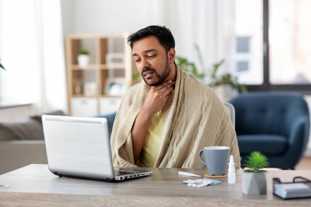 istock sick indian man having video call on laptop 1281634107