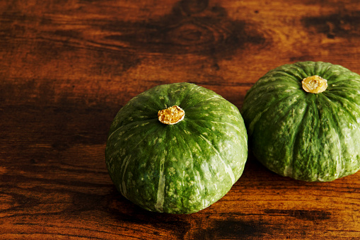 Multiple pumpkins on a wooden table.