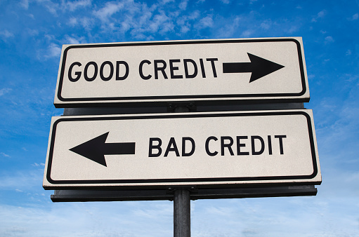 Good credit and bad credit road sign. White two street signs with arrow on metal pole with word. Directional road. Crossroads Road Sign, Two Arrow. Blue sky background. Two way road sign with text.