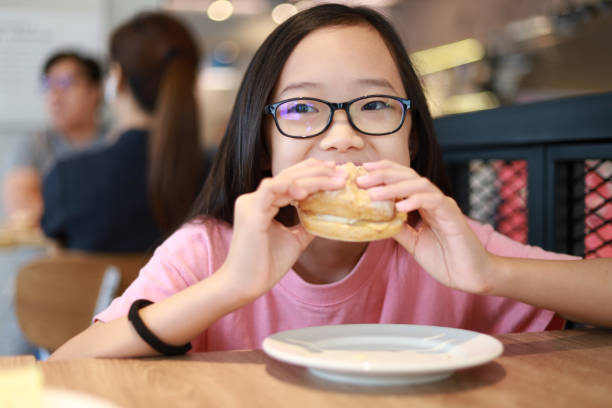 istock Girl eating sandwich in a cafe 1281637216