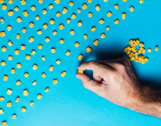 Man with obsessive compulsive disorder placing corn kernels neatly in a row
Obsessive compulsive disorder conceptual