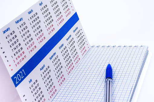 Notepad and calendar 2021, blue pen and Notepad on a white background