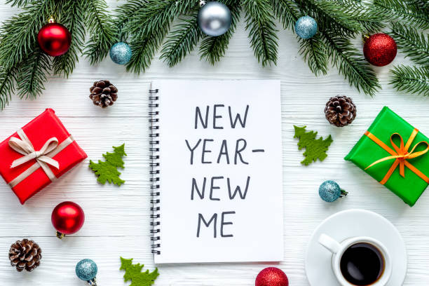 istock New year - new me. Christmas decorations and notebook on a table, flat lay 1281639573