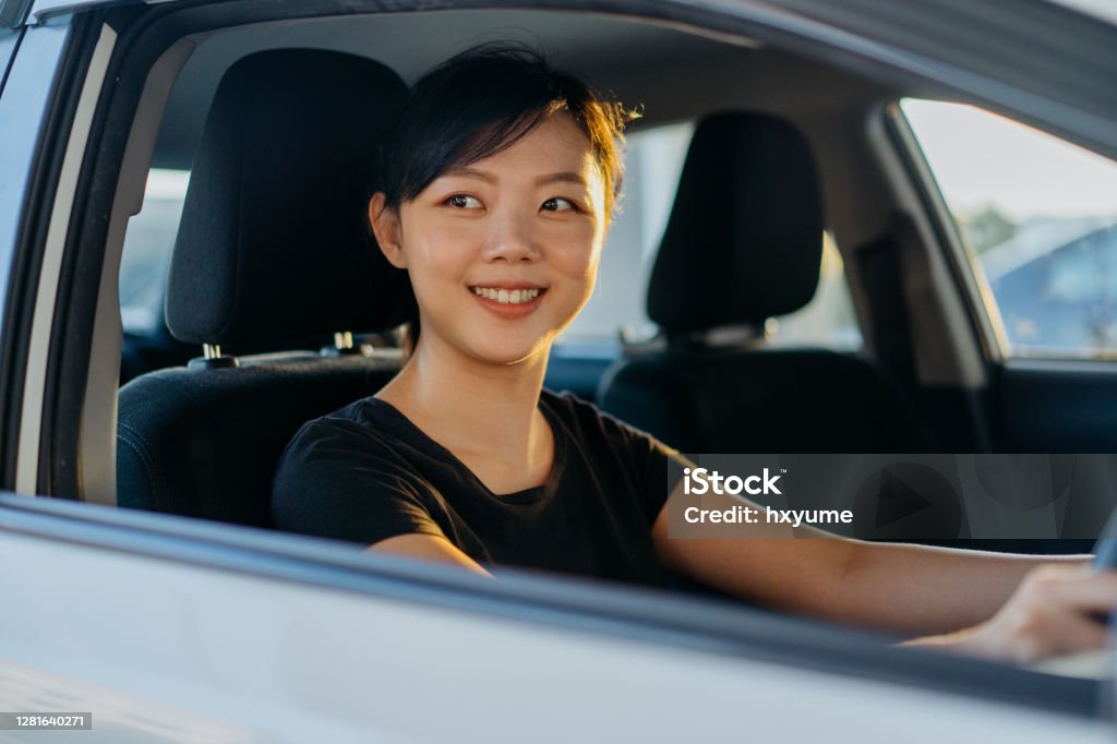Young asian woman driving a car Young asian woman driving a car and going out for work or travel Asian and Indian Ethnicities Stock Photo
