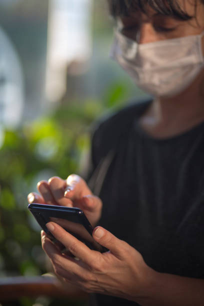 istock Young woman wearing protective face mask and using smart phone in a cafe. 1281640797