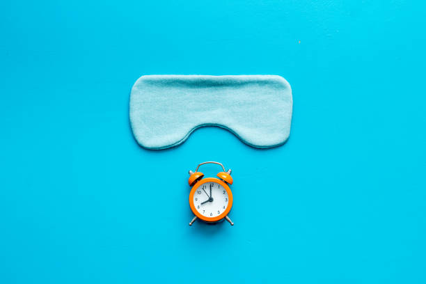 istock Insomnia concept. Sleep eye mask and alarm clock, top view 1281640836