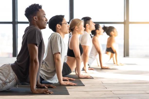 istock Side View Of Sporty Multiethnic People Practicing Yoga In Cobra Pose 1281641918