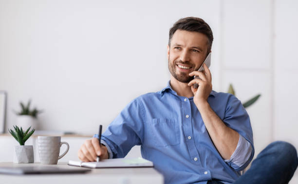 istock Business Communication. Successful Businessman Sitting At Workplace Talking On Cellphone With Client 1281642323