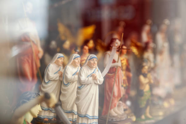 shop window displaying religious articles with small statues of Mother Teresa of Calcutta In focus