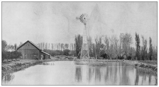 istock Antique black and white photograph: Reservoir and Windmill used in irrigation 1281643961
