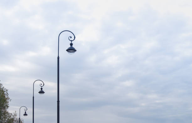 istock three street lamps against a cloudy sky 1281646459