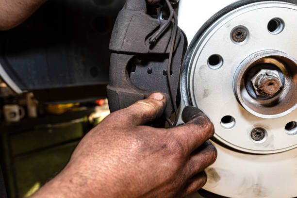 istock New brake disc with an anti-corrosion layer, mounted on the front hub, installing the brake pads, putting on the spring. 1281652116