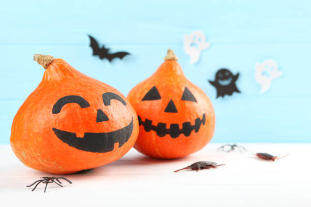 istock pumpkins with painted faces on a colored background for Halloween. 1281652199