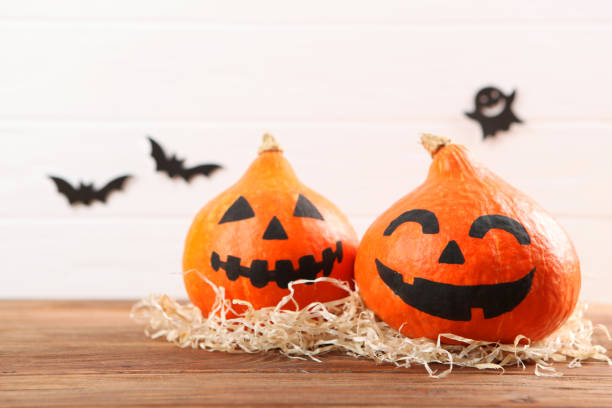 istock pumpkins with painted faces on a colored background for Halloween. 1281652200