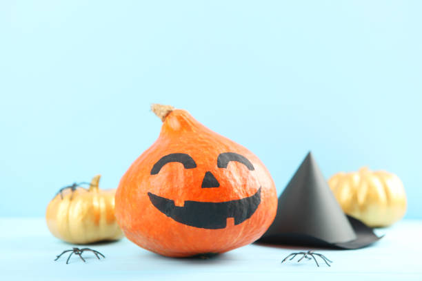 istock pumpkins with painted faces on a colored background for Halloween. 1281652208