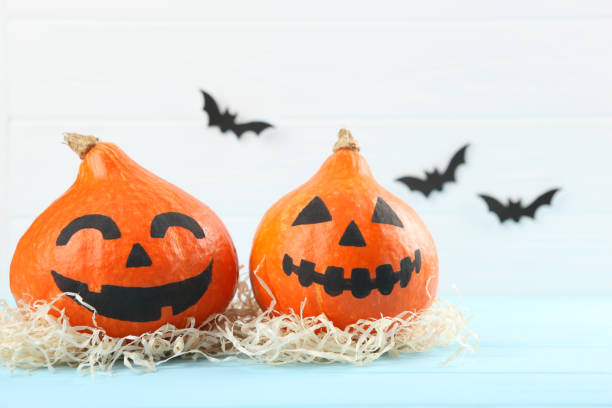 istock pumpkins with painted faces on a colored background for Halloween. 1281652246