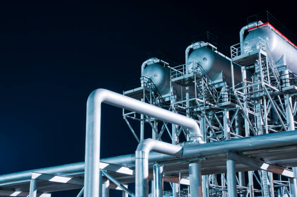 Industrial equipment at an oil refinery station at night stock photo