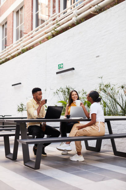 Dreams as big as their ambition Shot of a group of young businesspeople having a meeting outside of an office courtyard photos stock pictures, royalty-free photos & images