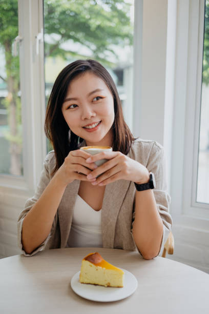 istock Young asian woman having a cheesecake in a cafe 1281653967