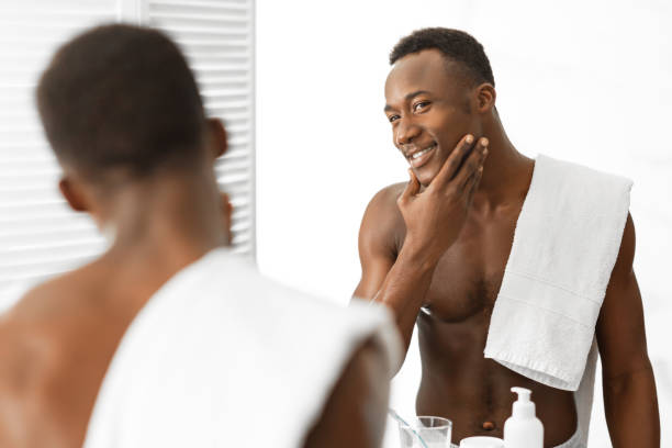 istock Black Guy Touching Well-Shaved Face Standing Shirtless In Modern Bathroom 1281654269