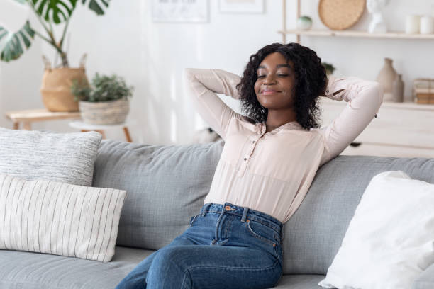 istock Lazy Day. Smiling Black Lady Leaning Back On Sofa With Closed Eyes 1281654304