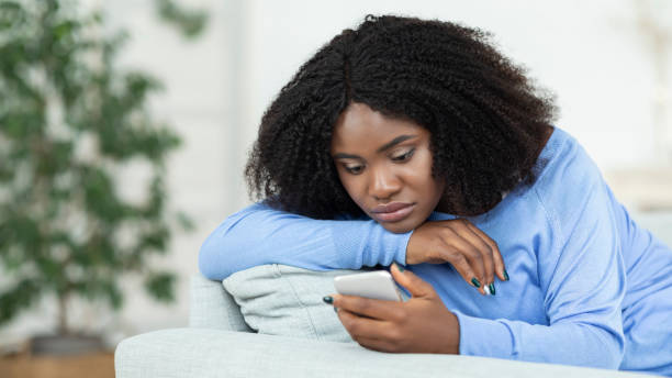 istock Frustrated lady checking mobile phone sitting on the couch 1281654516
