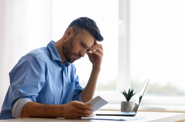 istock Concerned young businessman looking at smartphone while working in office, waiting message 1281654854