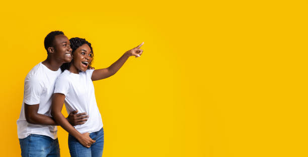 istock African-american man and woman pointing at empty space 1281655535