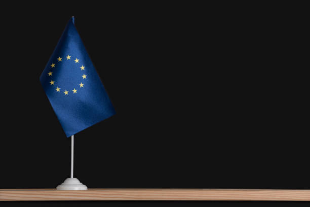 istock Flag pole, national table flag of EU on black background. Copy space 1281656639