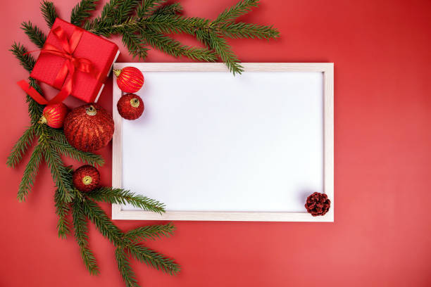 istock gift box, spruce branches, Christmas balls,frame on red background 1281659353