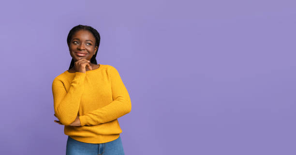 素敵なオファー。好奇心旺盛なアフリカの女性は、コピースペース、紫色の背景を見て - braids african descent women pensive ストックフォトと画像