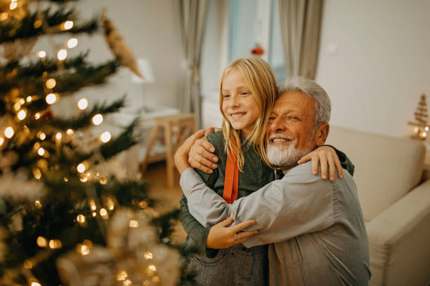 istock Senior man and granddaughter decorate christmas tree 1281661507