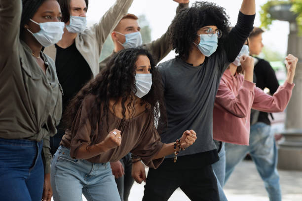 istock Young people in face masks attending demonstration on the street 1281663142