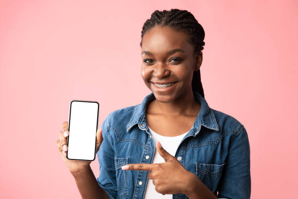 istock African Woman Showing Smartphone Blank Screen Posing Over Pink Background 1281663171