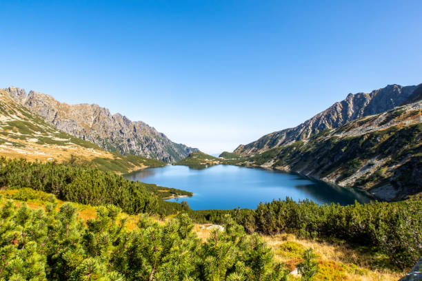 lago de montanha azul cristal, wielki staw, nas montanhas altas de tatra, vale dos cinco lagoas polonesas (dolina pieciu stawow polskich) no outono - tatra mountains zakopane lake mountain - fotografias e filmes do acervo