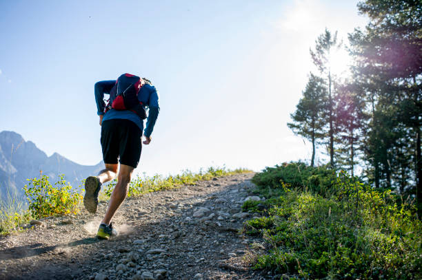 Man trail runs along mountain ridge at sunrise