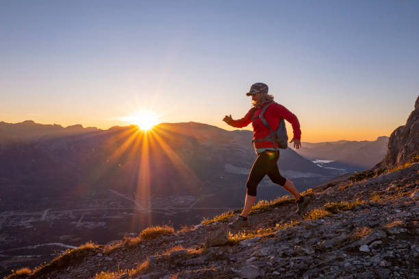 Woman hikes along mountain ridge at sunrise