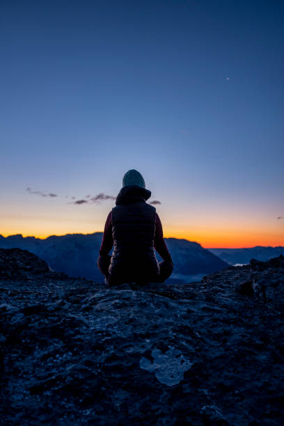 istock Woman meditates on mountain ridge at sunrise 1281667770