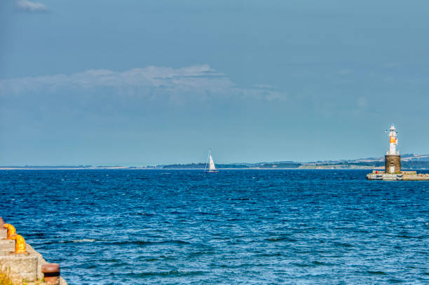 istock A small sailing boat in Aarhus harbour sails in a calm sea beside Arhus Lighthouse inspiring a romantic escape or a sport activity 1281668764