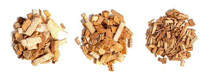 Various chips for smoking meat and fish isolated on white background top view. Heaps of wood chips from apple, pear and oak.