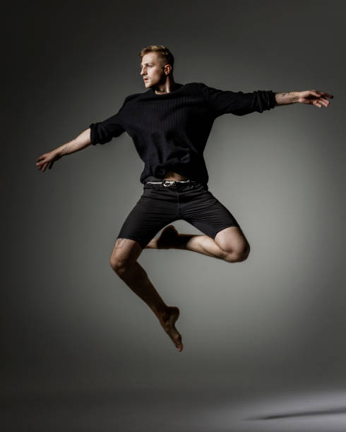 istock Male Dancer jumping on gray background 1281668834