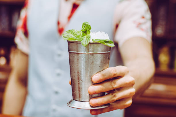 Bartender preparing delicious mint julep cocktail at table. Bartender preparing delicious mint julep cocktail at table mint julep photos stock pictures, royalty-free photos & images