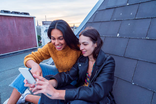 istock Cheerful girls on the rooftop enjoy a beer 1281670101