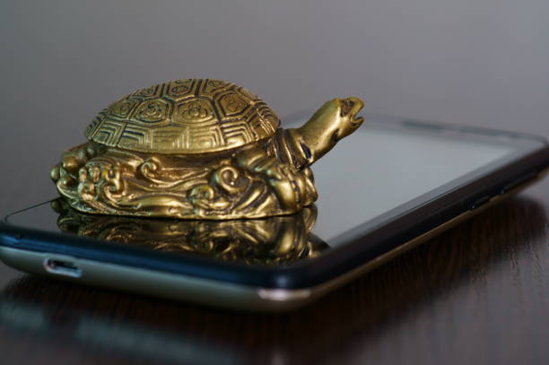 istock Metal turtle on a mobile phone. 1281670735