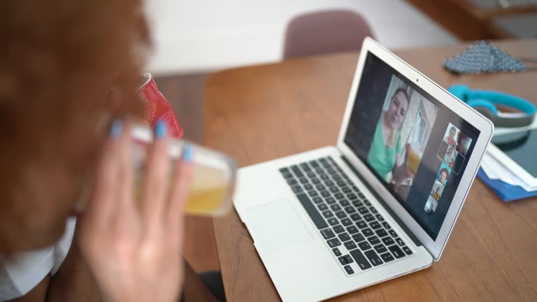 Woman cheering with friends on a video call at home