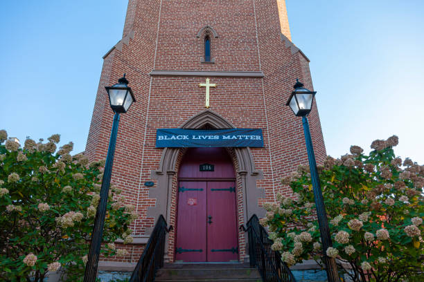 All Saints' is the oldest Episcopal parish in western Maryland. An anti racist banner hangs on top of its entrance door Frederick, MD, USA 10/13/2020: Founded in 1742, All Saints' is the oldest Episcopal parish in western Maryland. A Black Lives Matter banner hangs on top of its entrance door showing anti racist stance anglican eucharist stock pictures, royalty-free photos & images