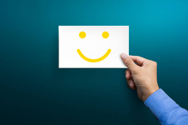 Customer service experience and satisfaction survey concepts. The client's hand holding the card with a happy face smile face.