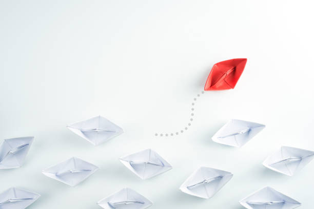istock Group of paper ship in one direction and one individual pointing in different way. innovative solution for business concept. 1281673192