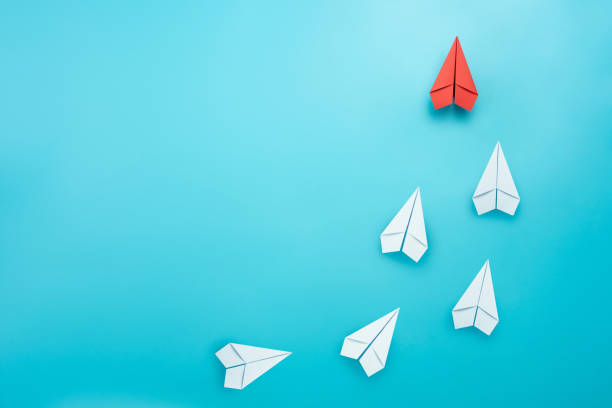 istock Leadership concept with red paper plane leading among white on blue background 1281673296